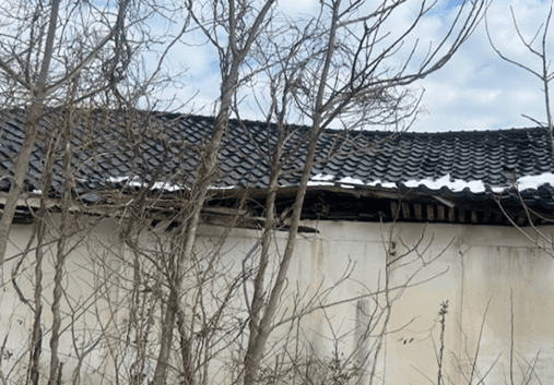 瓦が崩れ、下地が露出した建屋の屋根
